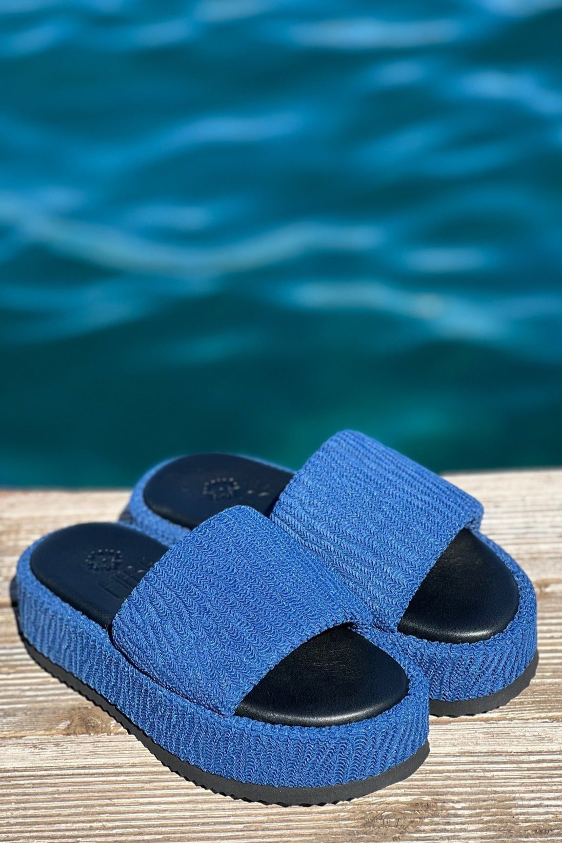 Pair of platform shoes in the sun on a timber deck