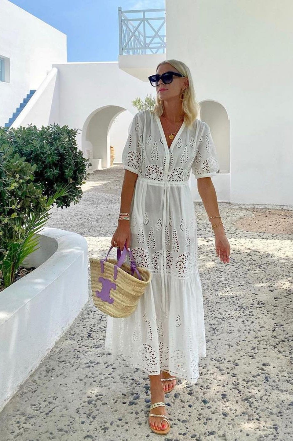 Model wearing white dress with gold sandals